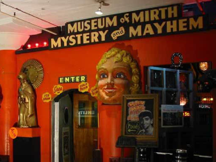 photo of a roadside museum with a banner reading "museum of mirth, mystery, and mayhem"