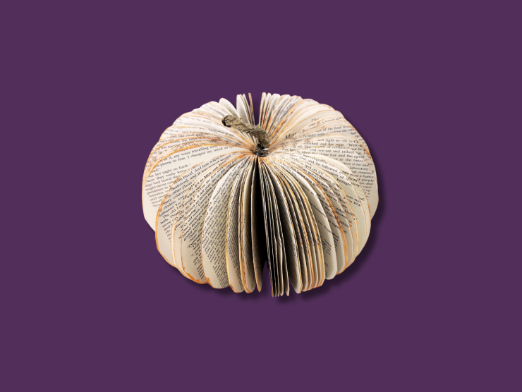 A purple background with a pumpkin made from a fanned out book and sprayed oranges edges.